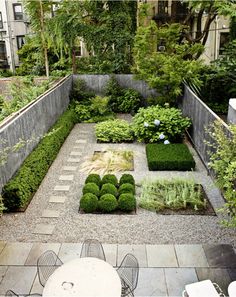 an image of a garden that is in the middle of a yard with bushes and plants