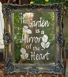 a sign that says the garden is a mirror of the heart with flowers on it