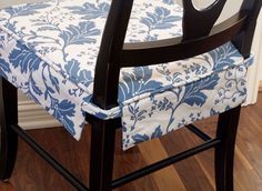 a chair with a blue and white floral seat cover on it's armrests