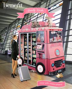 a woman is walking past a pink vending machine with cats on top and other items in it