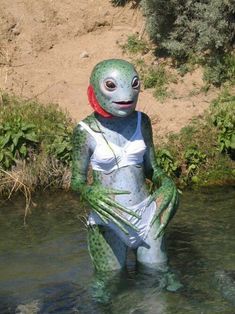 a woman in a body suit standing in the water with an octopus on her back