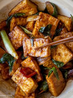 tofu and vegetables in a bowl with chopsticks