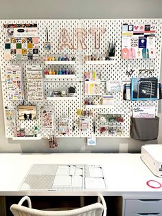 a desk with a white chair next to it and a bulletin board on the wall