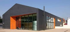 an orange and black building with two bikes parked in front of the entrance to it