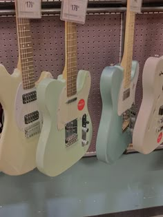 four electric guitars are on display in a store