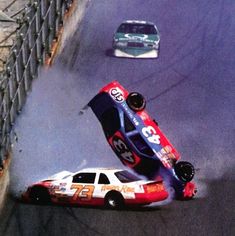 a car that is upside down on its side in the middle of a race track