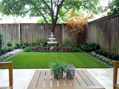 an outdoor patio with wooden tables and chairs in the middle of it, surrounded by greenery