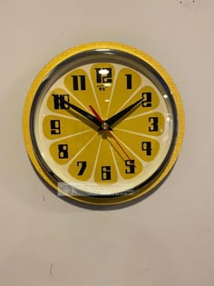 a yellow clock with black numbers on it