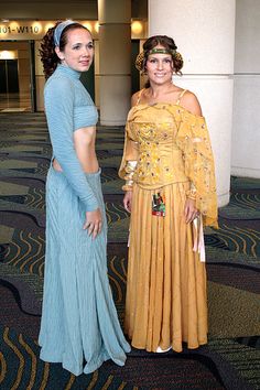 two women standing next to each other in front of a large room with carpeted floors