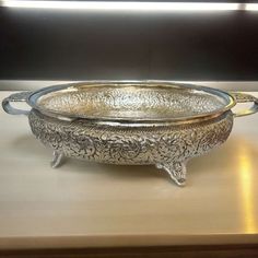 a silver bowl sitting on top of a wooden table