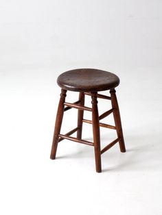 a wooden stool sitting on top of a white floor