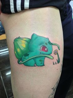 a person with a pokemon tattoo on their thigh and leg, holding a flower in her hand