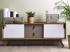 a white and brown sideboard with some plants on it next to a planter