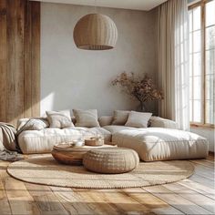 a living room filled with lots of furniture and pillows on top of a wooden floor