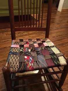 a wooden rocking chair with a patchwork seat cover on it's back and sides