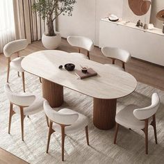 a dining table with six chairs around it and a potted plant in the corner