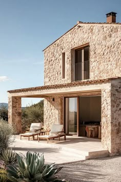 a stone house with an outdoor patio and seating area