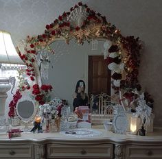 a woman is taking a photo in the mirror with her christmas decorations and gifts on the table