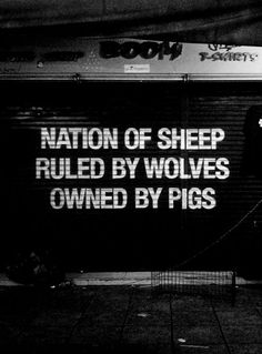 a black and white photo of a sign that says nation of sheep pulled by wolverines owned by pigs