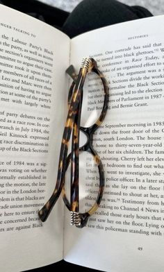 a pair of reading glasses resting on an open book