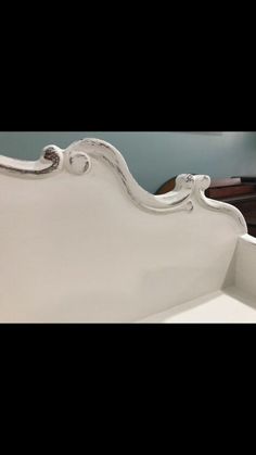 a white bed frame with an ornate headboard and foot board