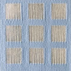 four rows of blue and white squares on a light blue background, with vertical stripes in the middle