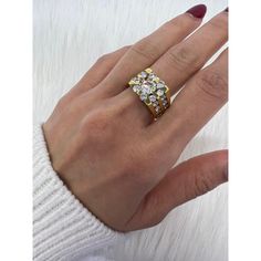 a woman's hand wearing a gold ring with three rows of diamonds on it