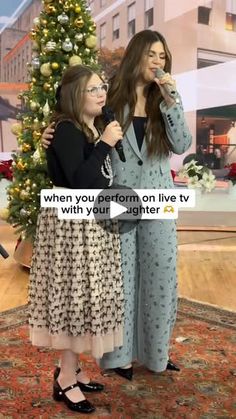 two women standing next to each other in front of a christmas tree with the caption, when you put form on live tv with your daughter