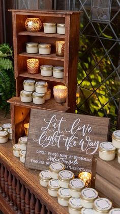 some jars and candles are sitting on a table with a sign that says let love light the way