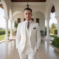 a man in a white suit and tie standing on a tiled floor next to an archway