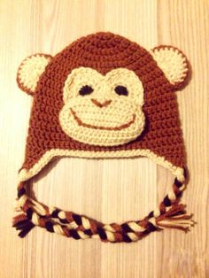 a crocheted monkey hat on top of a wooden table