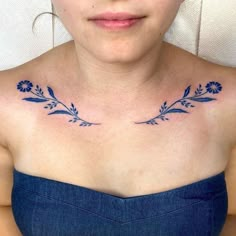 a woman's chest with blue flowers on it