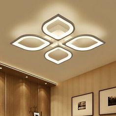 the modern ceiling light has four square shaped lights on it's sides and is mounted above a bed