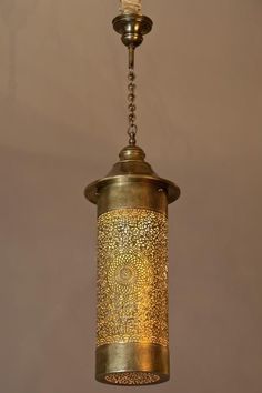 a brass colored light fixture hanging from a ceiling with a chain attached to the bottom