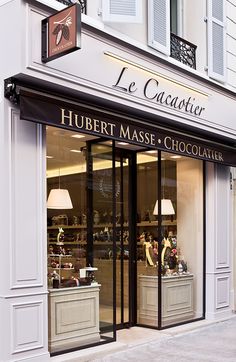 a store front with two lamps on the outside and one lamp in the window that says, le cauvrier