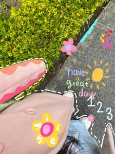 a child's chalk drawing on the ground next to flowers