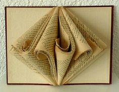 an origami folded book with pages in the shape of flowers