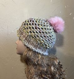 a knitted hat with a pink pom - pom on top