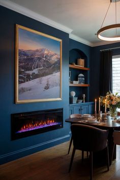 A dining room with a dark blue accent wall featuring a fireplace for added coziness. Fireplace Inspiration, Stylish Dining Room, The Judge