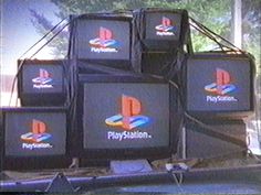 several televisions stacked on top of each other in front of a building with logos