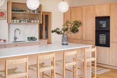 a kitchen with wooden cabinets and white counter tops next to an island in the middle