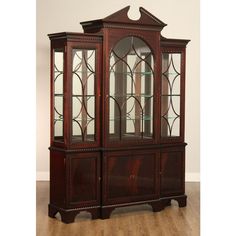 a wooden china cabinet with glass doors on the top and bottom shelves in an empty room