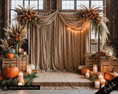 a stage set up with pumpkins, candles and greenery for a fall wedding