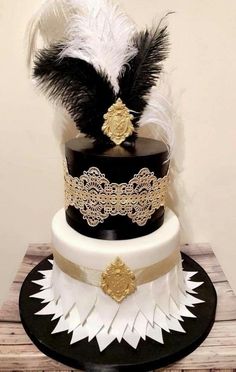 a three tiered cake with black, white and gold decorations