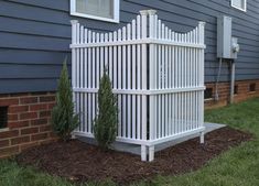 a white fence in front of a blue house