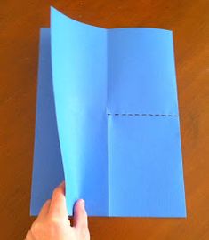 someone is holding an open blue piece of paper