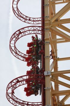 people are riding on the roller coaster at an amusement park