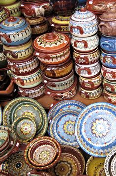 there are many bowls and plates on display