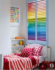 a bed room with a neatly made bed next to a window covered in colorful blinds