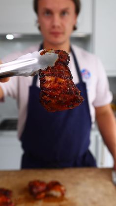 a man is holding up a piece of meat